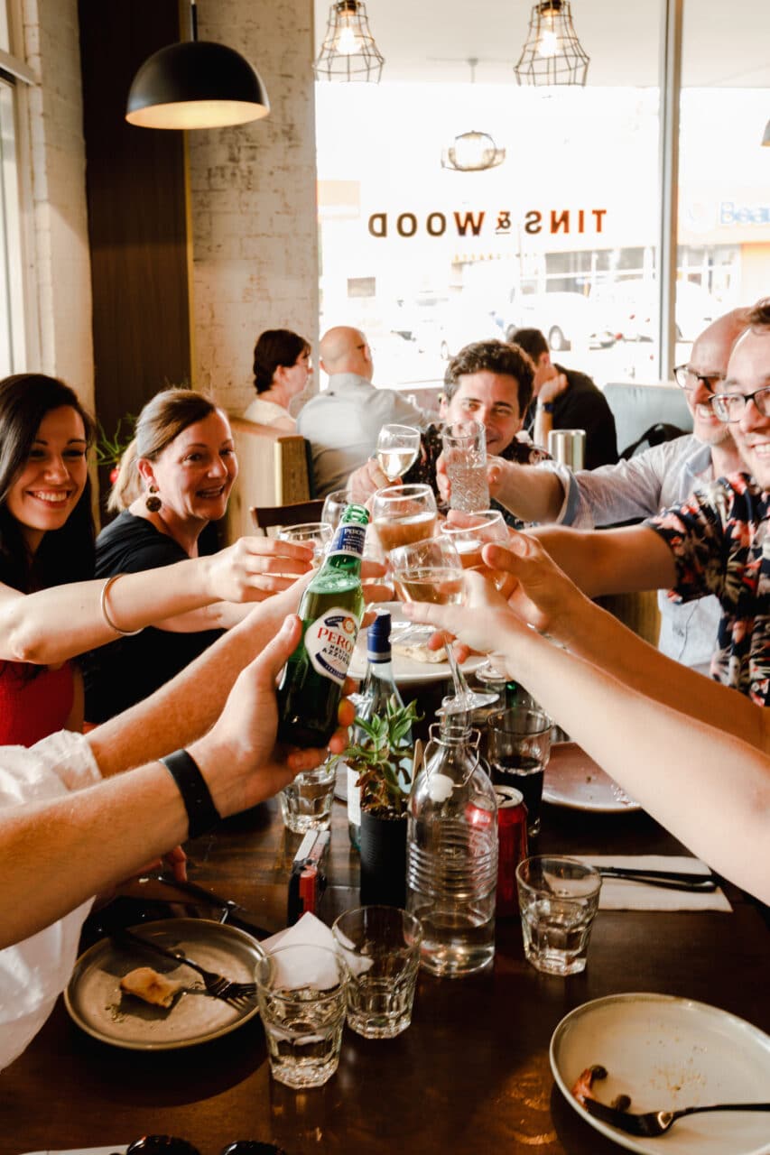 A group of people doing a cheers at Tins & Wood Penrith